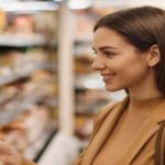 英会話学習の例として店内の商品棚を見ながら微笑む女性