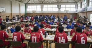 箱根駅伝に出場する大学選手が体育館で食事を取る様子とシューズメーカーの勢力図を象徴するイメージ